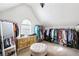 Bright walk-in closet featuring custom organization system with rods, drawers, shelving, and ottoman seating at 322 Berkshire Trce, Canton, GA 30115