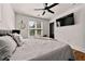 Spacious bedroom with a gray bed, ceiling fan, and mounted TV at 726 Charlotte Pl, Atlanta, GA 30318