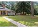 Brick walkway leads to a spacious backyard with a screened porch and mature trees at 1790 Garraux Nw Rd, Atlanta, GA 30327