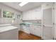 Bright laundry room with white cabinets and terra cotta tile floor at 1790 Garraux Nw Rd, Atlanta, GA 30327