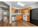 Galley kitchen with wood cabinets, tile backsplash, stainless steel dishwasher, and black refrigerator at 5615 Strathmoor Manor Cir, Lithonia, GA 30058