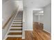 Staircase with wood stairs and white risers leading to a living area with wood flooring at 5615 Strathmoor Mnr, Lithonia, GA 30058