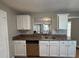 Kitchen with white cabinets, granite countertops, and a double sink at 6403 Walnut Way, Union City, GA 30291