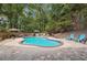Inviting kidney-shaped pool surrounded by a patio and lush greenery at 2505 Ridgehurst Dr, Buford, GA 30518