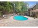 Relaxing kidney-shaped pool with patio, surrounded by trees at 2505 Ridgehurst Dr, Buford, GA 30518