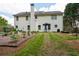 A backyard with a patio with a grill and table with umbrella. Also a garden with plants and a two story house at 42 Millstone Gln, Dallas, GA 30157