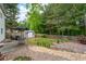 A backyard with a patio table and seating, and a storage shed, garden area and grass yard at 42 Millstone Gln, Dallas, GA 30157