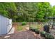 Landscaped backyard featuring a shed, flower garden and mature trees at 42 Millstone Gln, Dallas, GA 30157