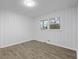 Clean bedroom featuring wood-look flooring, neutral paint, and a bright window at 132 Arnold Pl, Jonesboro, GA 30236