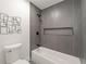 Modern bathroom with gray tile, bathtub, and updated fixtures at 1167 Key Se Rd, Atlanta, GA 30316