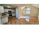 Open kitchen with hardwood floors, white cabinets, and stainless steel appliances at 256 Kings Cv, Locust Grove, GA 30248