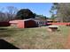 A spacious backyard with a shed and a red brick barbecue grill, enclosed by a red fence for added privacy at 1988 Glenmar Dr, Decatur, GA 30032