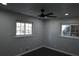 Calming bedroom featuring two windows, a ceiling fan, and neutral gray walls and trim at 1988 Glenmar Dr, Decatur, GA 30032