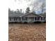 Gray Ranch style home with a covered porch and mature trees surrounding the property at 6540 Old White Mill Rd, Fairburn, GA 30213