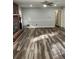 Bright living room with wood-look flooring and access to other rooms at 6540 Old White Mill Rd, Fairburn, GA 30213