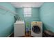 Laundry area showcases a washer, dryer, wire rack, and an organized cart for supplies, set against blue walls at 39 Lambeth Dr, Hiram, GA 30141