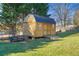 Wooden shed with a metal roof, complete with double doors and a ramp, set against a blue sky at 39 Lambeth Dr, Hiram, GA 30141