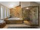 Spa-like bathroom with a large shower, jacuzzi tub and stone feature wall at 10170 Cedar Grove Rd, Chattahoochee Hills, GA 30213