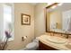 Elegant powder room with marble vanity and framed mirror at 10170 Cedar Grove Rd, Chattahoochee Hills, GA 30213