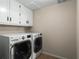 Laundry room with LG washer and dryer and white cabinets at 10170 Cedar Grove Rd, Chattahoochee Hills, GA 30213