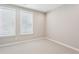 Simple bedroom with neutral walls, carpeting, and two windows at 1095 Tucker Ave # 501, Atlanta, GA 30310