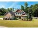 Brick two-story house with a landscaped lawn and mature trees at 307 Cinnamon Bark Pass, Locust Grove, GA 30248