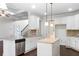 Open concept kitchen with white cabinets, granite countertops and stainless steel appliances at 307 Cinnamon Bark Pass, Locust Grove, GA 30248