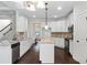 Open concept kitchen with island, white cabinets, and granite countertops at 307 Cinnamon Bark Pass, Locust Grove, GA 30248