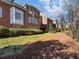 Landscaped backyard with pine straw and brick homes at 335 Enclave Cir, Atlanta, GA 30342