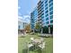 An outdoor seating area with tables, chairs, and a manicured lawn in front of a modern building at 40 12Th Ne St # 1701, Atlanta, GA 30309