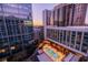An aerial view showcasing a rooftop pool with lounge chairs and umbrellas, surrounded by city buildings at 40 12Th Ne St # 1701, Atlanta, GA 30309