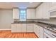 L-shaped kitchen with white cabinets, granite counters at 1735 Peachtree Ne St # 129, Atlanta, GA 30309