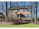 Brick two-story house with green shutters, landscaping, and stone retaining wall at 4187 Westchester Ne Trce, Roswell, GA 30075