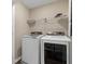 Bright laundry room with washer, dryer, and overhead shelving at 372 Provenance Dr, Sandy Springs, GA 30328