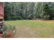 Large grassy backyard with a fire pit and privacy fence at 45 Highland Park Way, Sharpsburg, GA 30277