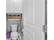 Small bathroom with a toilet and wall-mounted storage at 45 Highland Park Way, Sharpsburg, GA 30277