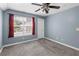 Bright bedroom featuring carpet, large window, and ceiling fan at 45 Highland Park Way, Sharpsburg, GA 30277