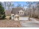 Two-story house with attached garage and driveway, nestled amongst trees at 80 Valley Dr, Stockbridge, GA 30281