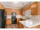 Galley kitchen with wood cabinets and black appliances at 80 Valley Dr, Stockbridge, GA 30281