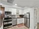 Modern white kitchen with stainless steel appliances and brick accent wall at 856 Briarcliff Ne Rd # 25, Atlanta, GA 30306