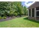 Backyard view showcasing green lawn and mature trees at 5540 Fords Crossing Nw Ct, Acworth, GA 30101