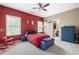 Red-walled bedroom with a red bedspread and a blue footrest at 5540 Fords Crossing Nw Ct, Acworth, GA 30101