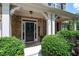 Inviting front entrance with a black door, landscaping, and a covered porch at 5540 Fords Crossing Nw Ct, Acworth, GA 30101