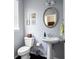 Stylish powder room with pedestal sink, toilet, and dark wood floor at 5540 Fords Crossing Nw Ct, Acworth, GA 30101