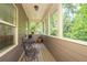 Relaxing screened porch with table and chairs, offering wooded views at 5540 Fords Crossing Nw Ct, Acworth, GA 30101
