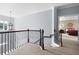 Upstairs landing overlooking main floor with carpet and wrought iron railing at 5540 Fords Crossing Nw Ct, Acworth, GA 30101