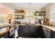Charming kitchen with black cabinets, butcher block counters, stainless appliances, open shelving, and a view to another room at 257 Vance Ne Cir, Marietta, GA 30060