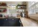 Well-lit kitchen featuring black cabinets, butcher block countertops, stainless steel appliances, and open shelving at 257 Vance Ne Cir, Marietta, GA 30060