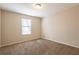 Neutral bedroom with window and neutral colored carpet and paint at 4547 Doral Sw Dr, Atlanta, GA 30331