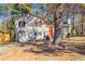 Charming two-story home with vinyl siding and a bright orange front door surrounded by mature trees at 4547 Doral Sw Dr, Atlanta, GA 30331